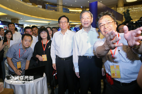 在“動(dòng)漫展區(qū)”,來(lái)自臺(tái)灣的陳天賞向張志軍介紹利用紅色龍蝦殼制作的“蝦兵蝦將”。