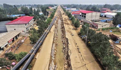 洪水將坑內(nèi)的管道沖到路邊。京華時(shí)報(bào)記者潘之望攝