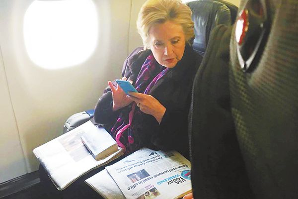 3日,希拉里在飛機上看副總統彭斯“郵件門”事件的報道。