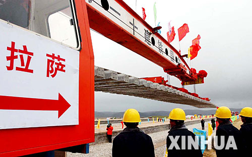 西藏境內第一段鐵路軌排在安多火車站鋪下,鐵軌將從這里向拉薩繼續延伸(2004年6月22日攝)。 青藏鐵路從西寧至拉薩全長1956公里,是世界上海拔最高、線路最長、穿越凍土里程最長的高原鐵路。把鐵路修進西藏是幾代中國人的夢想,但這一想法直到新中國成立后才逐漸變為現實。青藏鐵路一期工程西寧至格爾木段于1958年開工,1984年交付營運。但限于當時國家的經濟實力以及高原、凍土等筑路技術難題尚未解決,格爾木至拉薩段被迫停建。2001年6月,國家總投資330.9億元動工修建青藏鐵路二期工程。這一工程跨越昆侖山、唐古拉山,通過多年凍土層和大片“生命禁區”,是人類鐵路建設史上亙古未有的穿越。它的建成將為神秘而古老的青藏高原帶來新的生機和活力! 新華社發